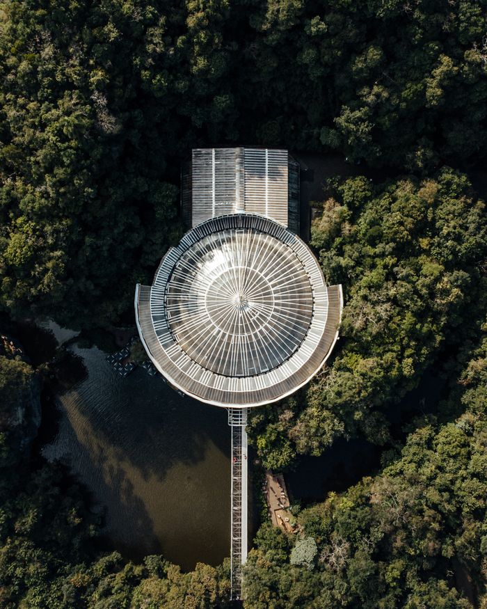 A stunning aerial shot captures the architecture of Bosque do Papa amidst lush greenery in Curitiba, Brazil.